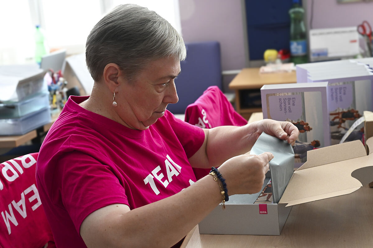 Gerti G. (Teilnehmerin Jugend am Werk) beim Packen der Bonusboxen