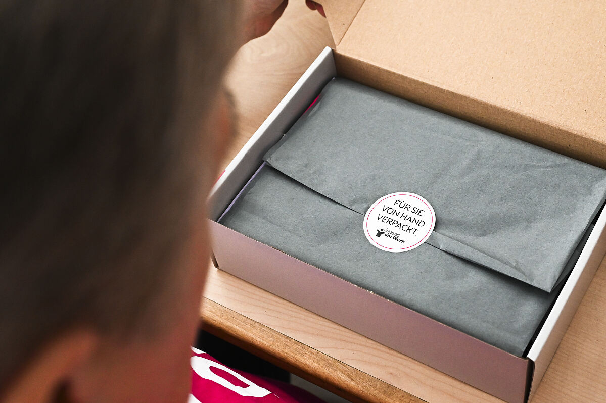 Gerti G. (Teilnehmerin Jugend am Werk) beim Packen der Bonusboxen